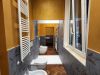 bagno con sanitari sospesi, parquet e rivestimento in gres con decoro floreale